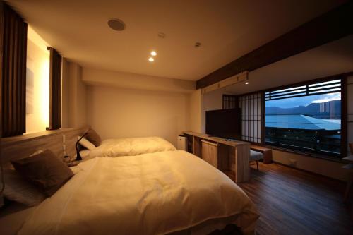 a bedroom with a large bed and a large window at Hotel Miyajima Villa in Miyajima