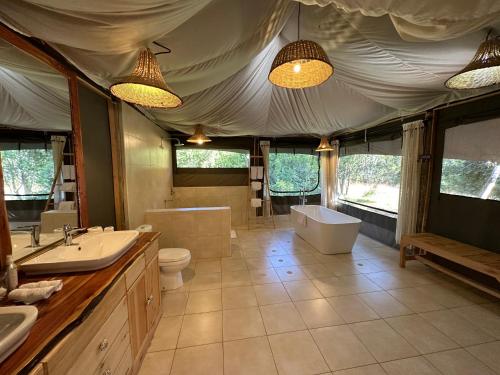 a bathroom with a tub and a toilet and a sink at Olesamara Collection in Nanyuki