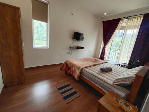 a bedroom with a large bed and a large window at Cloud & Mist Inn, Kotagiri in Kotagiri