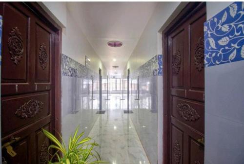 um corredor vazio com portas de madeira e uma planta em Hotel Antonio's Nr Calangute Beach em Calangute