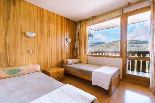 1 Schlafzimmer mit 2 Betten und einem großen Fenster in der Unterkunft APPART ZIG-ZAG LES COCHES in Les Coches