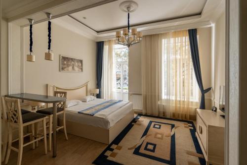 sypialnia z łóżkiem, stołem i biurkiem w obiekcie Metro Hotel Apartments w Odessie