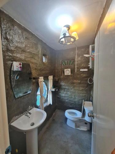 a small bathroom with a sink and a toilet at ตั้วบ้านดิน Tuabaandin in Ban Thung Phan Ha