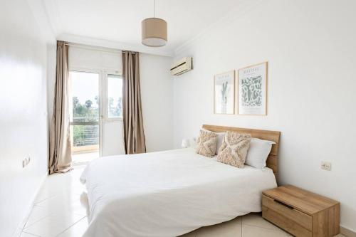 um quarto branco com uma cama grande e uma janela em Rabat Centro Apartments em Rabat