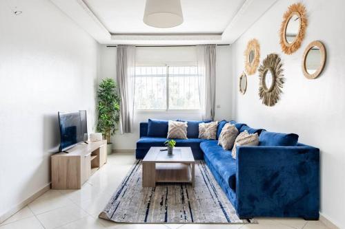 uma sala de estar com um sofá azul e uma mesa em Rabat Centro Apartments em Rabat