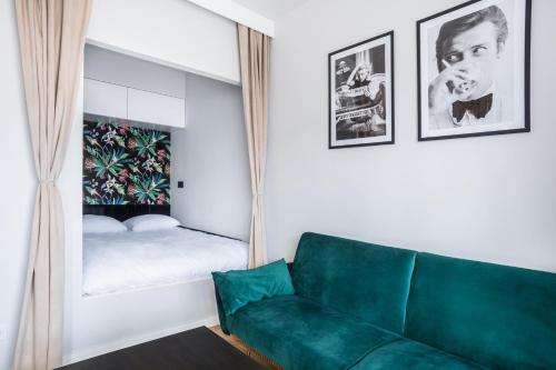 a living room with a green couch and a mirror at Nowe Ptasie, Osiedle Ptasie, apartment 30, NEW - LUX - PARKING in Katowice