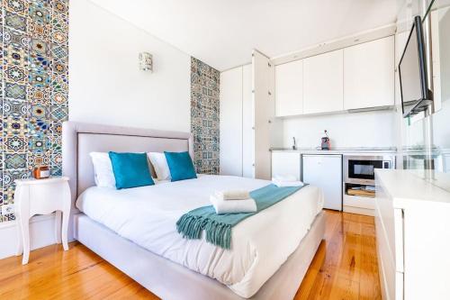 ポルトにあるVIVA Mosaics Studioの大きな白いベッドと青い枕のある寝室