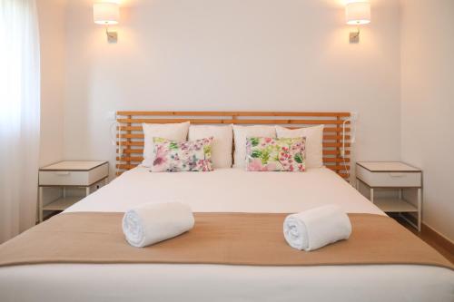 a bedroom with a large white bed with pillows at I Love Dão Casas Da Fraga in São Gemil