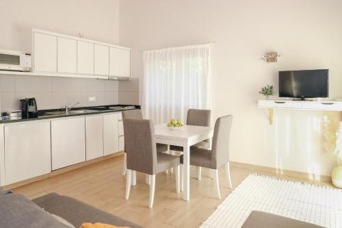 a kitchen and dining room with a white table and chairs at I Love Dão Casas Da Fraga in São Gemil