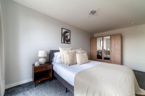 a bedroom with a large white bed and a nightstand at The Stratford Collection in London