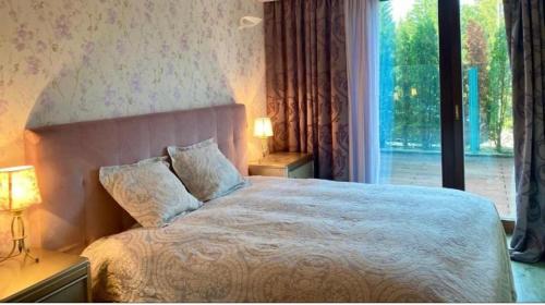 sypialnia z dużym łóżkiem i dużym oknem w obiekcie Penthouse Silver Mountain, Duplex 3 camere - 250 mp luxury garden - Poiana Brasov w Braszowie