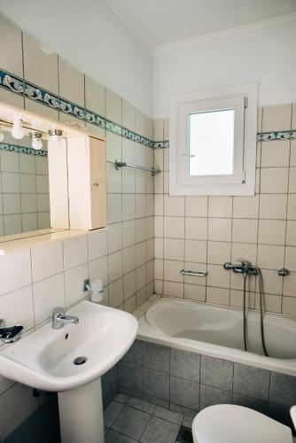 a bathroom with a sink and a bath tub at Villa Swan in Lefkada