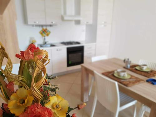 a kitchen with a table with a vase of flowers at Residence Boccaccio in Torre Pali 