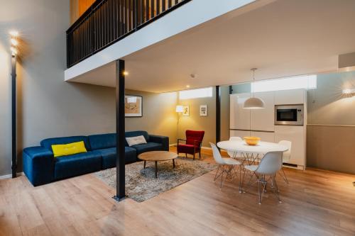 a living room with a blue couch and a table at Apartments De Hallen in Amsterdam