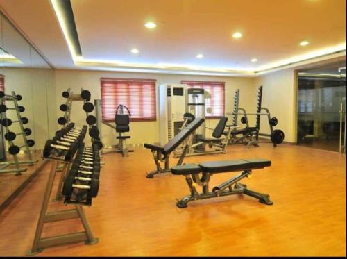 a gym with several treadmills and machines in a room at Relaxing Studio at Morgan Suites walking distance Venice Piazza T219P in Manila