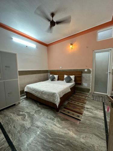 a bedroom with a bed and a ceiling fan at Flow House in Rishīkesh