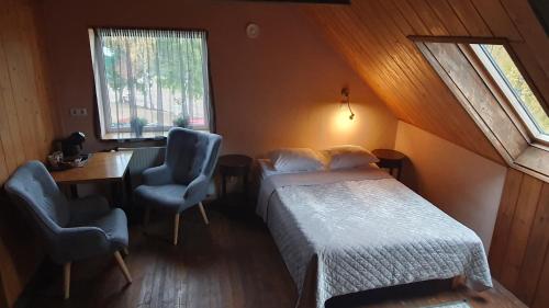 een slaapkamer met een bed, een bureau en 2 stoelen bij Kütioru puhkekeskus in Koloreino