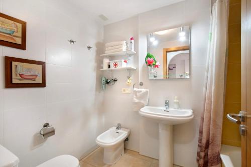 a white bathroom with a sink and a toilet at Residencial en el Médano in El Médano