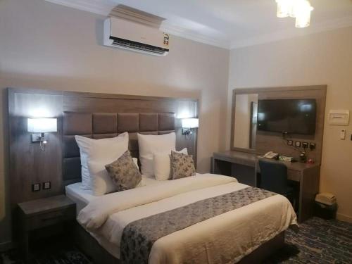 a hotel room with a large bed and a television at فندق اجنحة السمو بجازان in Jazan