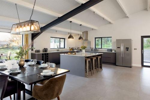 a kitchen and living room with a table and chairs at Quantock Barn in Monkton