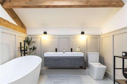 a bathroom with a tub and a toilet and a sink at old school house in Skipton