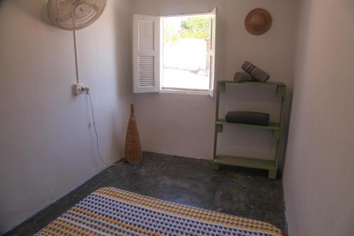 a room with a rug on the floor and a window at Calango Hostel in Ibicoara