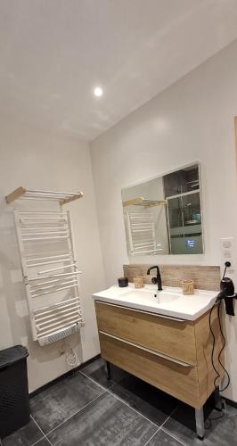 une salle de bain avec un lavabo et un miroir dans l'établissement Les Gentianes, à Saint-François-Longchamp