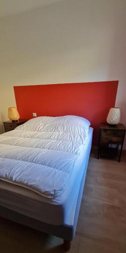 - une chambre avec un lit doté d'une tête de lit rouge dans l'établissement Les Gentianes, à Saint-François-Longchamp