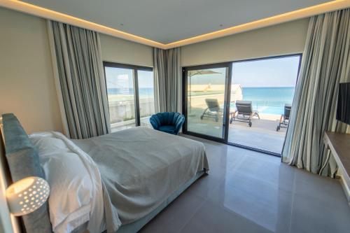 um quarto com uma cama e vista para o oceano em Villa Halcyon em Agios Stefanos