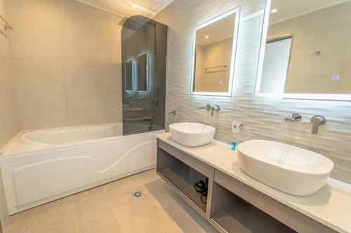 阿吉歐史芬尼的住宿－Villa Halcyon，浴室配有两个盥洗盆和浴缸。