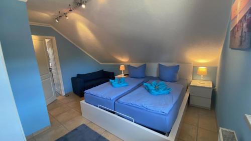 a bedroom with a bed with blue sheets and blue pillows at Seenebel in Prerow