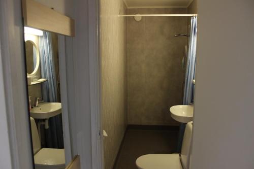 a bathroom with a toilet and a sink and a shower at Motelli Nuttulinna in Nuttupera