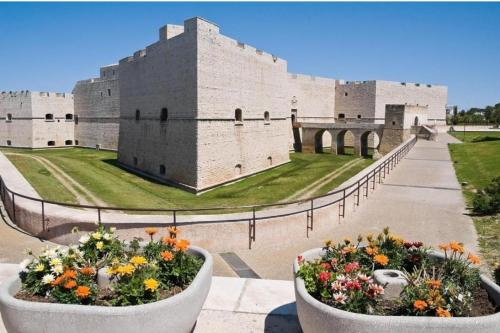 un castello con due grandi vasi di fiori davanti di Casa Bonelli 37 a Barletta