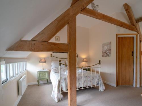 a bedroom with a bed with a wooden frame at Pass the Keys Hare Cottage wonderful views and parking in Moreton in Marsh
