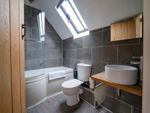 a bathroom with a toilet and a tub and a sink at Pass the Keys Hare Cottage wonderful views and parking in Moreton in Marsh