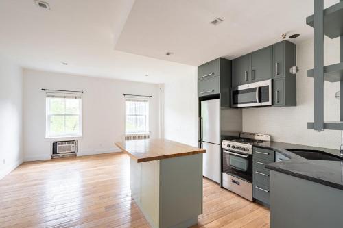 een keuken met grijze kasten en een houten vloer bij Apartment 1287: Chelsea in New York