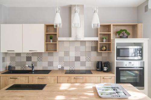 - une cuisine avec des placards en bois et des appareils blancs dans l'établissement L'Agave Nantaise - Jolie maison à 15min de Nantes, à Vertou