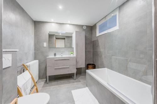 une salle de bain avec une baignoire, un lavabo et des toilettes dans l'établissement L'Agave Nantaise - Jolie maison à 15min de Nantes, à Vertou