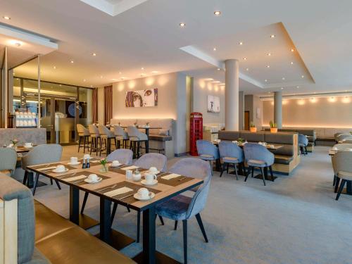 un restaurant avec des tables et des chaises ainsi qu'un bar dans l'établissement Novotel München Messe, à Munich