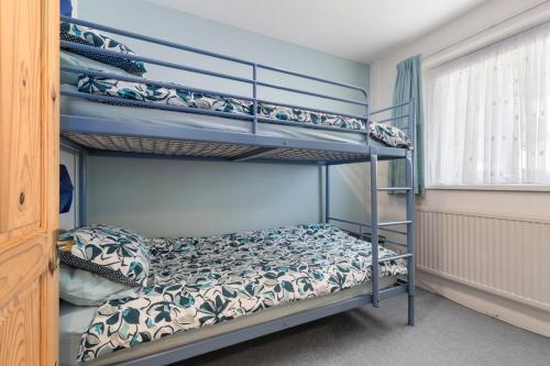 une chambre avec deux lits superposés dans une pièce dans l'établissement Oaklands - Lovely Cottage Walk to Beach, à Saundersfoot