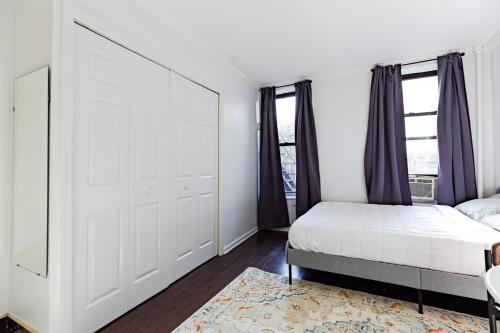 a bedroom with a bed and a large window at Apartment 1720: East Village in New York