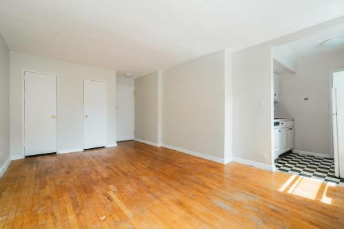 Habitación vacía con suelo de madera y paredes blancas. en Apartment 1333: East Village, en Nueva York