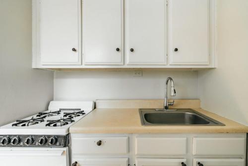 cocina blanca con fregadero y fogones en Apartment 1333: East Village, en Nueva York