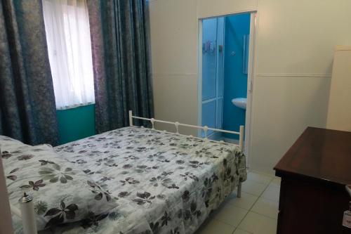 ein kleines Schlafzimmer mit einem Bett und einer blauen Tür in der Unterkunft Palm Grove in Colombo