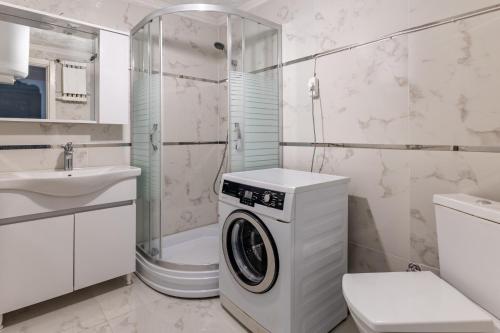 a white bathroom with a washing machine in it at Flat with Balcony 3 min to Public Transportation in Istanbul