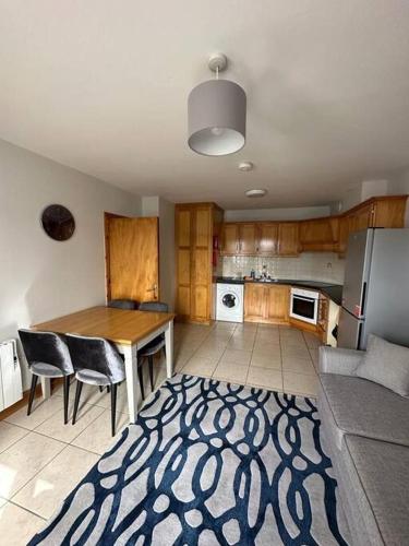 cocina con mesa, sillas y nevera en Snug apartment centrally located, en Galway