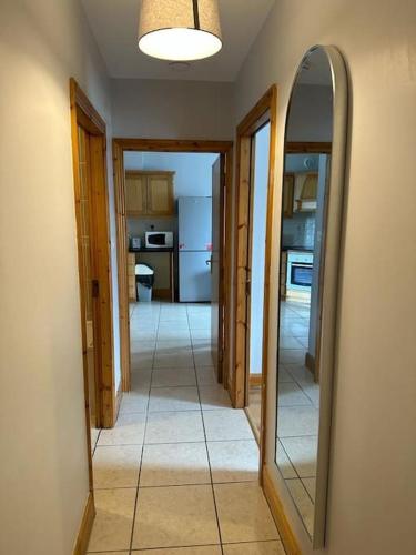 a room with a hallway with two mirrors and a kitchen at Snug apartment centrally located in Galway