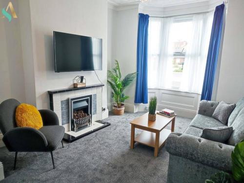 a living room with a couch and a fireplace at St Bernard House TSAC in Stockton-on-Tees