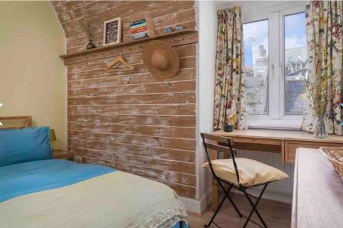 ファルマスにあるHarbour Strandのレンガの壁のベッドルーム、ベッド1台、デスクが備わります。
