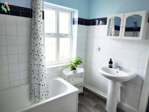 biała łazienka z umywalką, wanną i umywalką w obiekcie St Bernard House TSAC w mieście Stockton-on-Tees